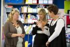 Three educators standing together in a classroom setting