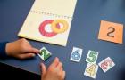 Childs hand working on an activity with numbers and letters