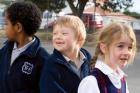 Three primary age children lining up in the playground Three primary age children lining up in the playground